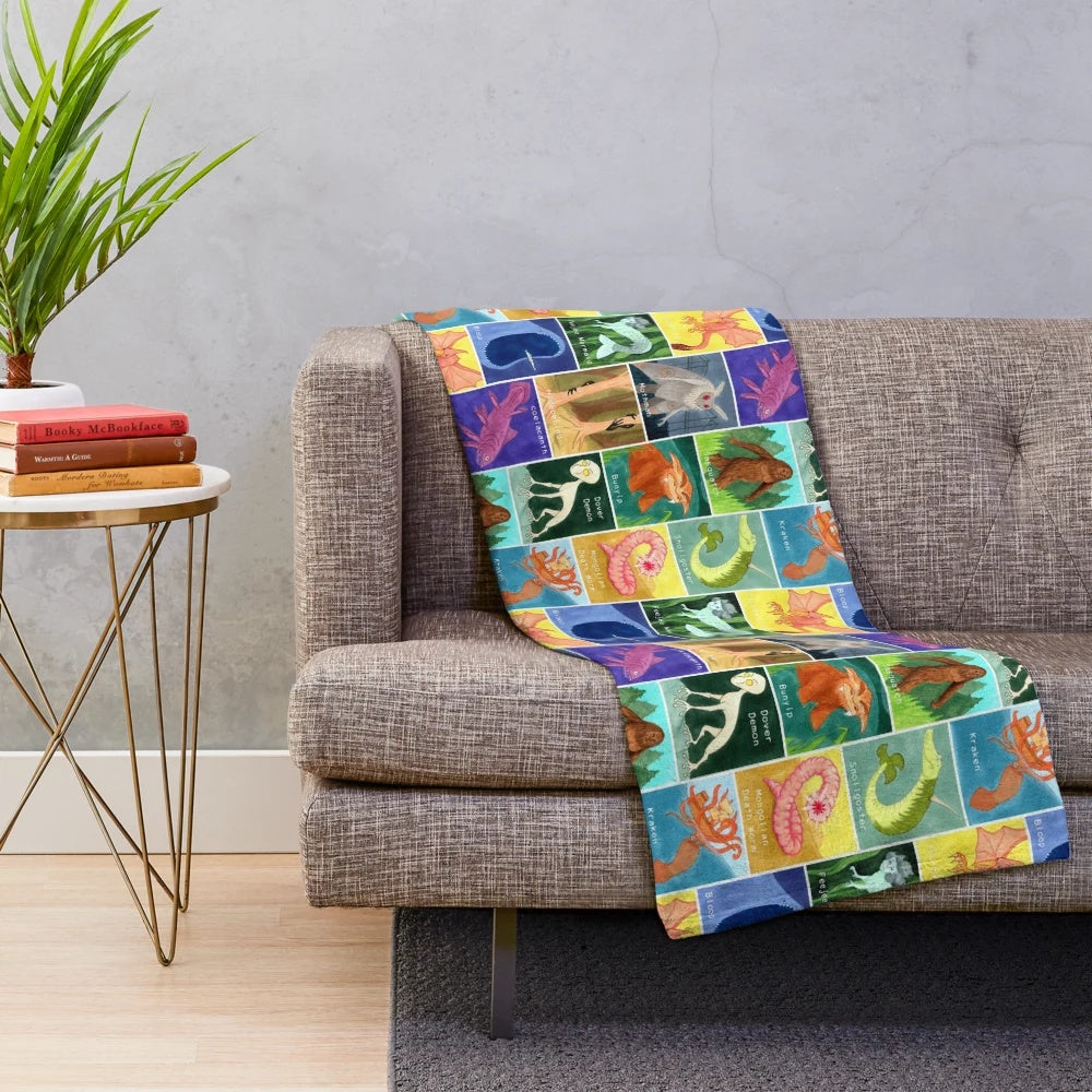Creepy cute cryptid plush blanket featuring a variety of mysterious creatures