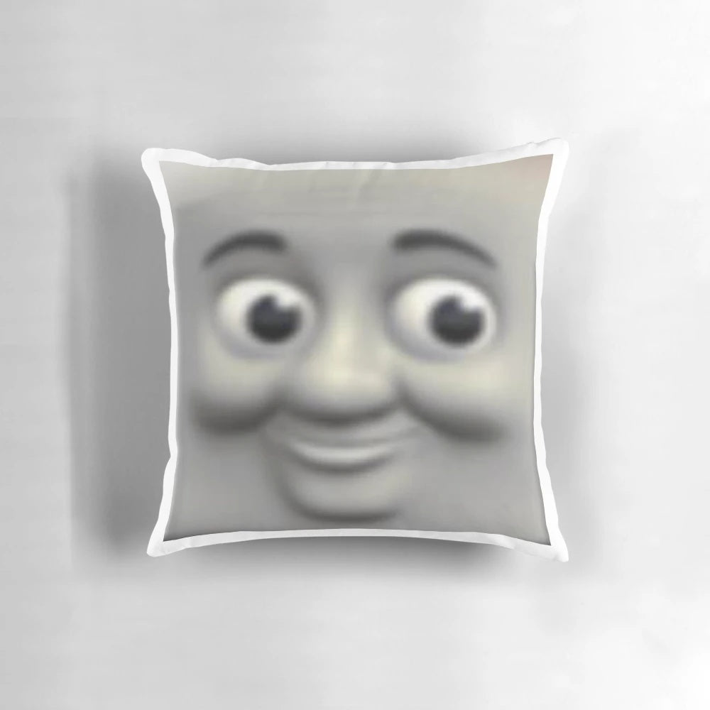 A Thomas the Tank Engine-themed pillow with the character's face prominently displayed, creating a unsettling, meme-worthy design.