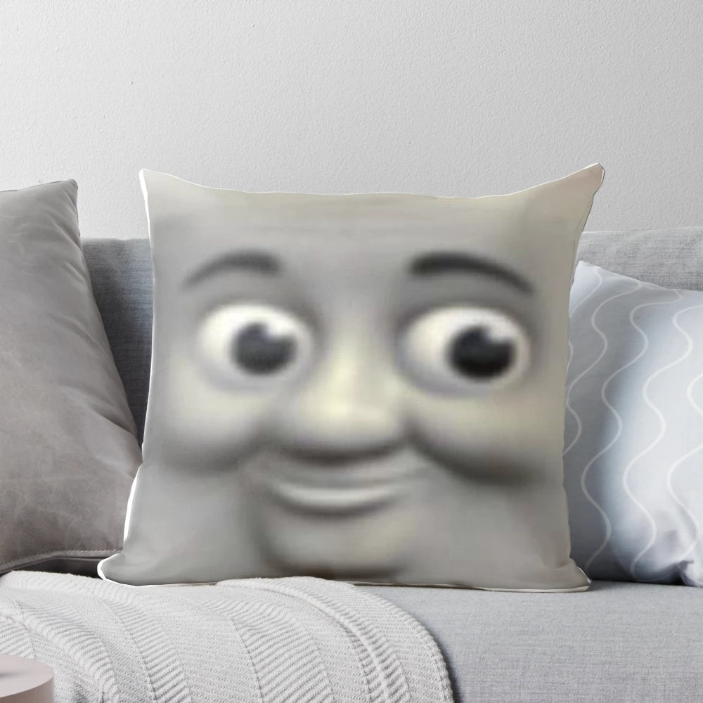 A Thomas the Tank Engine-themed pillow with the character's face prominently displayed, creating a unsettling, meme-worthy design.