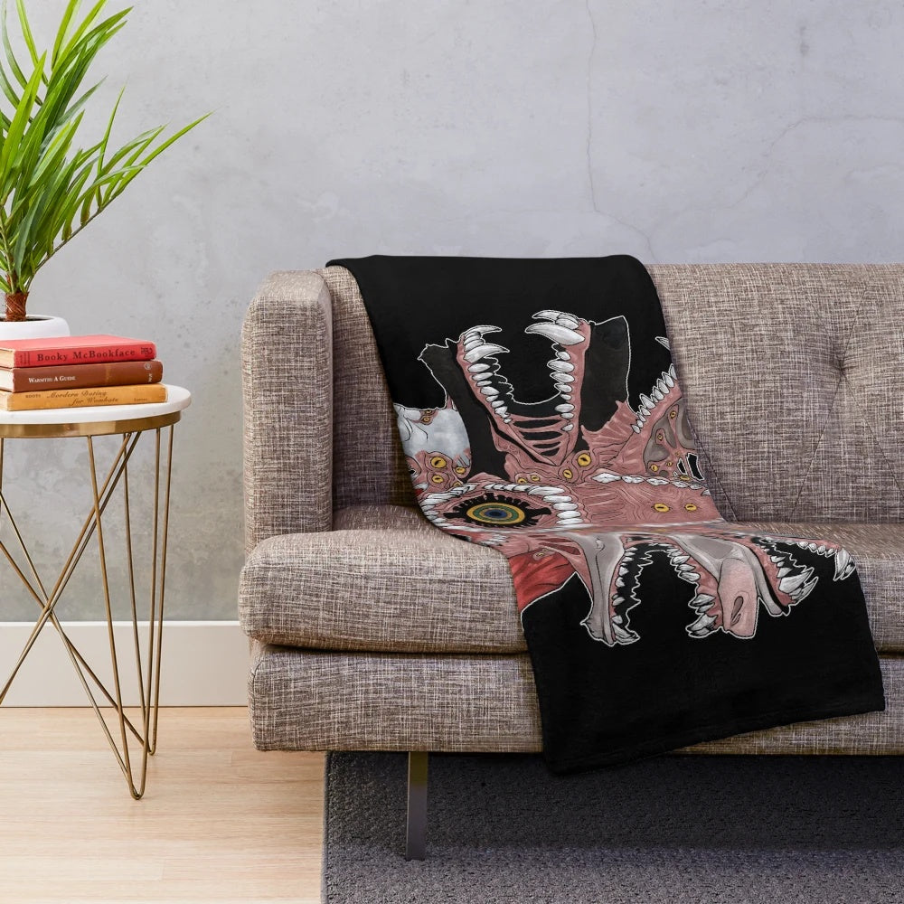 Creepy plush blanket with 30 yard grin pattern featuring eyes, teeth, and other unsettling elements