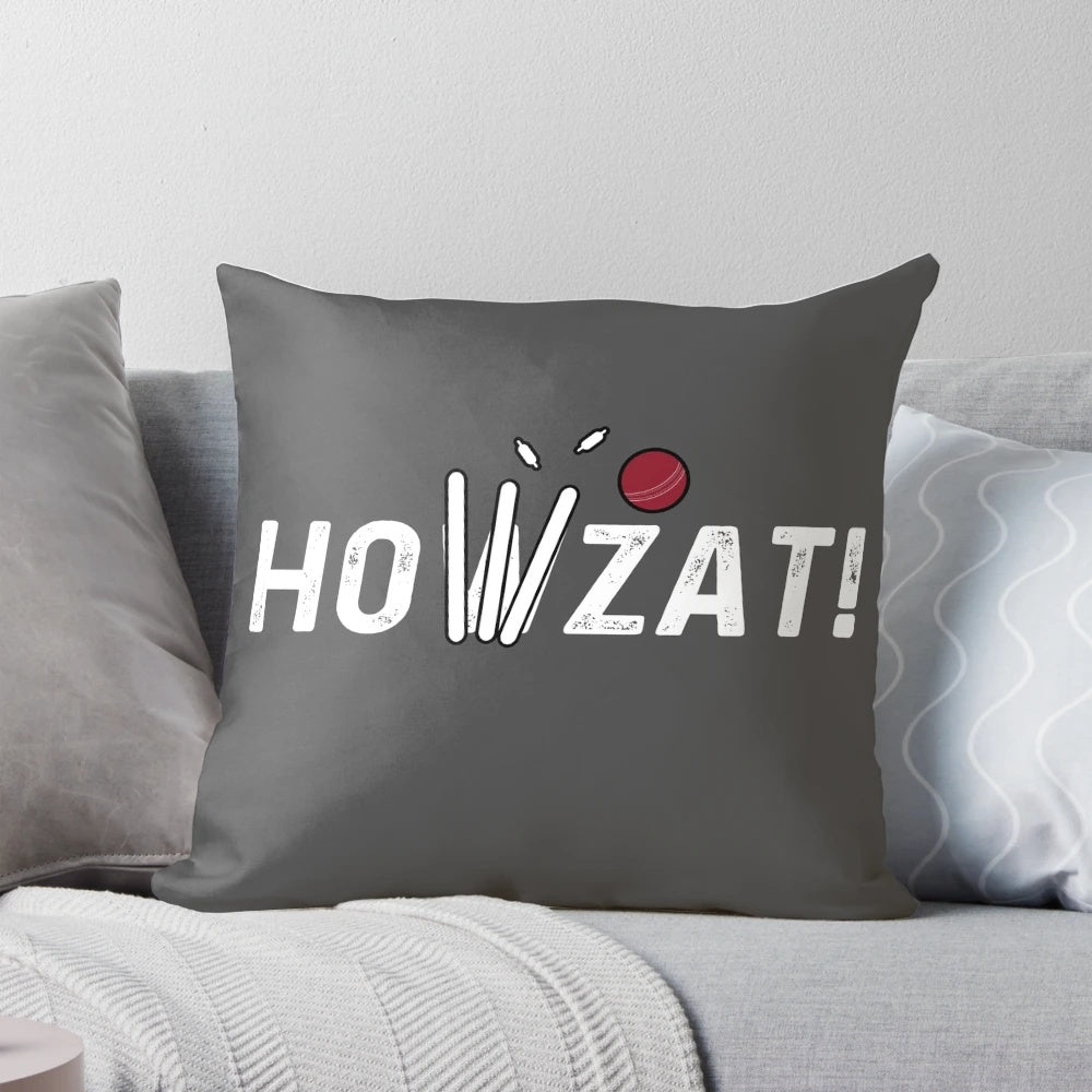 A decorative pillow featuring a cricket-themed design with a howzat, ball, and wicket.