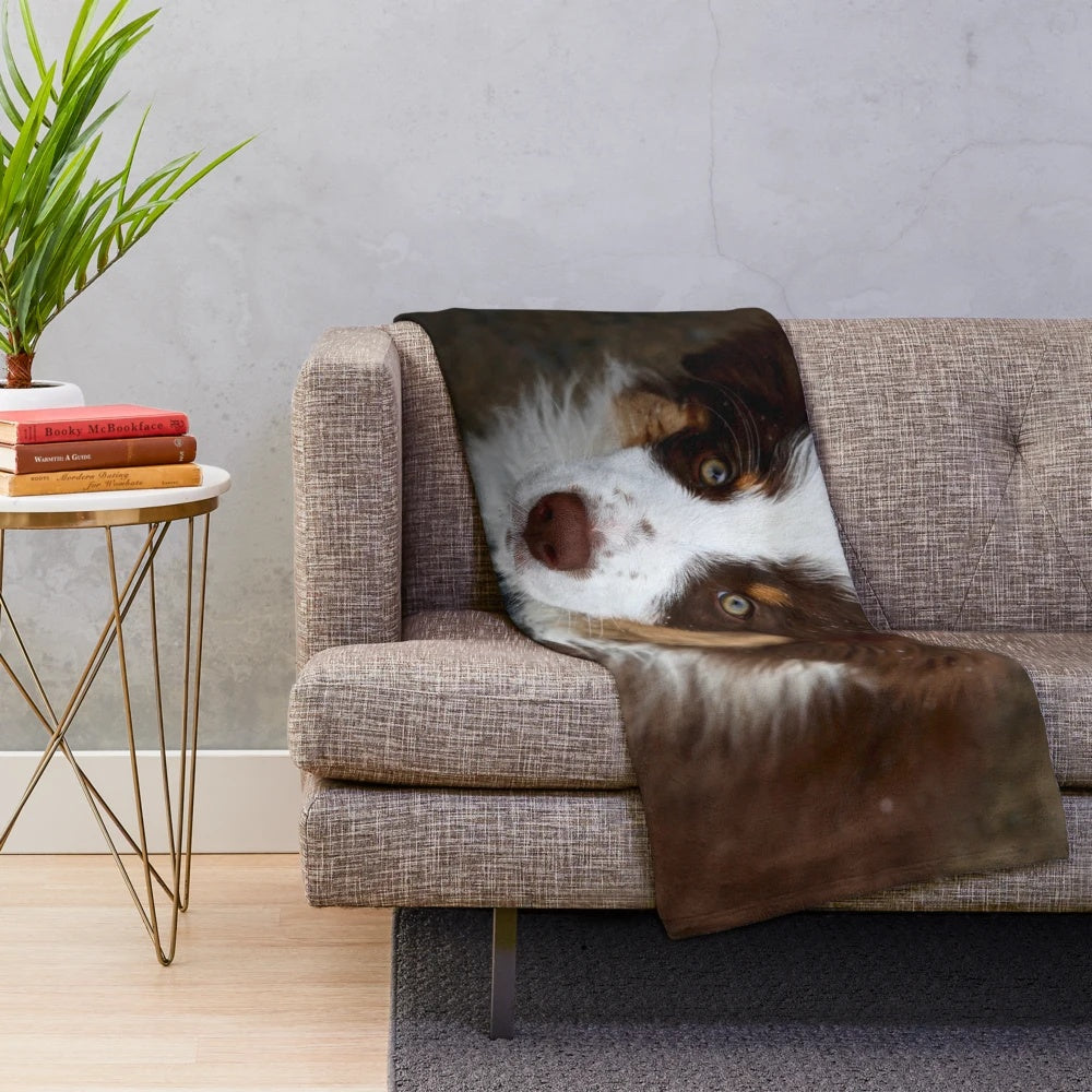 Adorable Australian shepherd puppy snuggled in a soft plush blanket