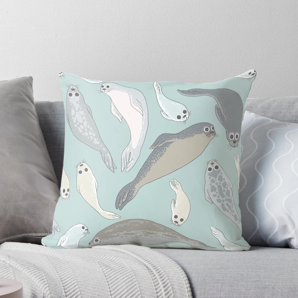 A soft, plush pillow shaped like a baby seal with realistic fur and features.
