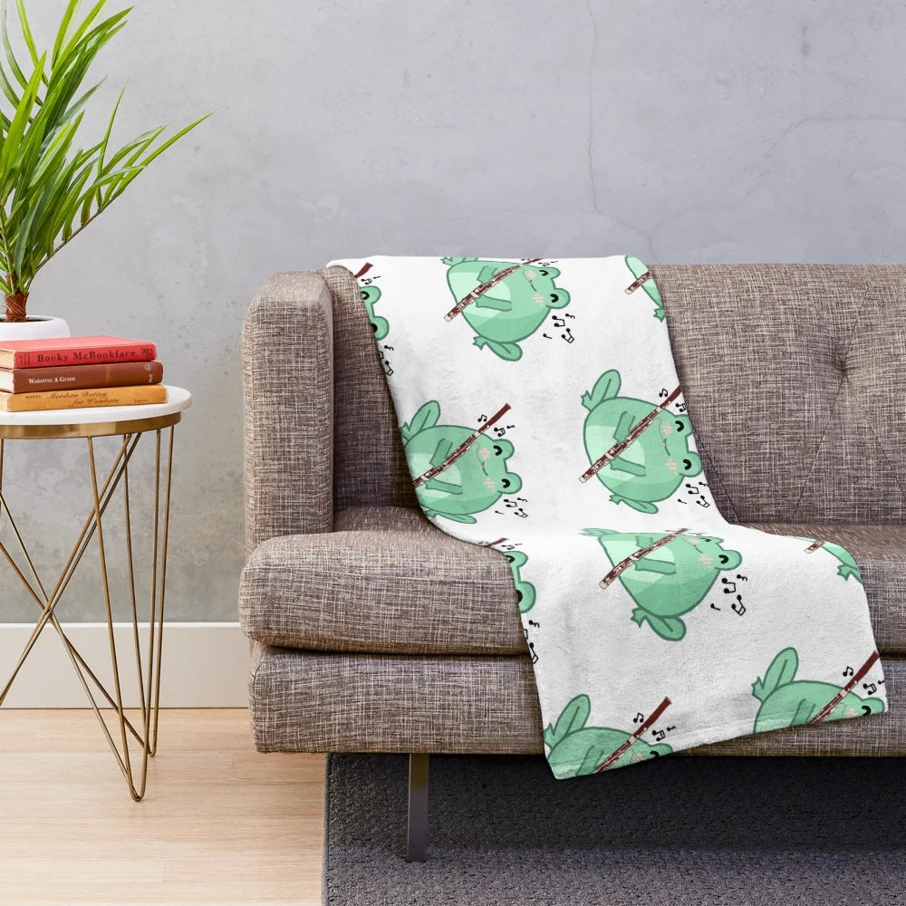 Cozy plush blanket featuring a cute frog playing the bassoon musical instrument