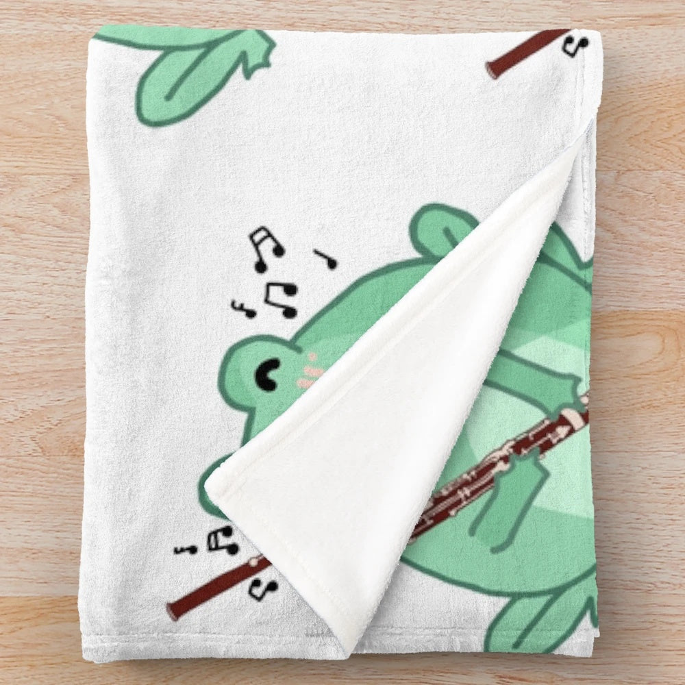 Cozy plush blanket featuring a cute frog playing the bassoon musical instrument