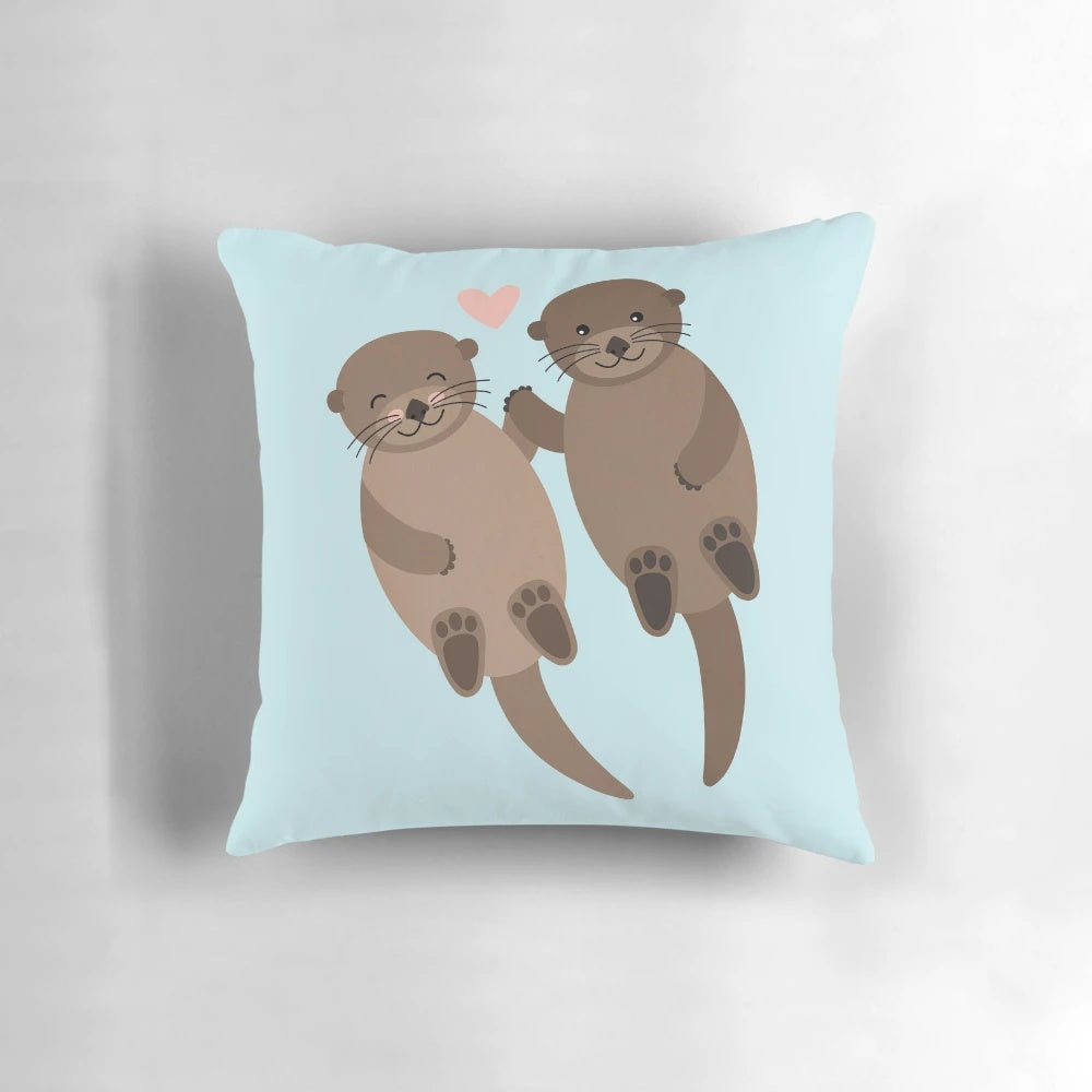 Soft, plush pillow featuring a heart-shaped design with two adorable otters cuddling.