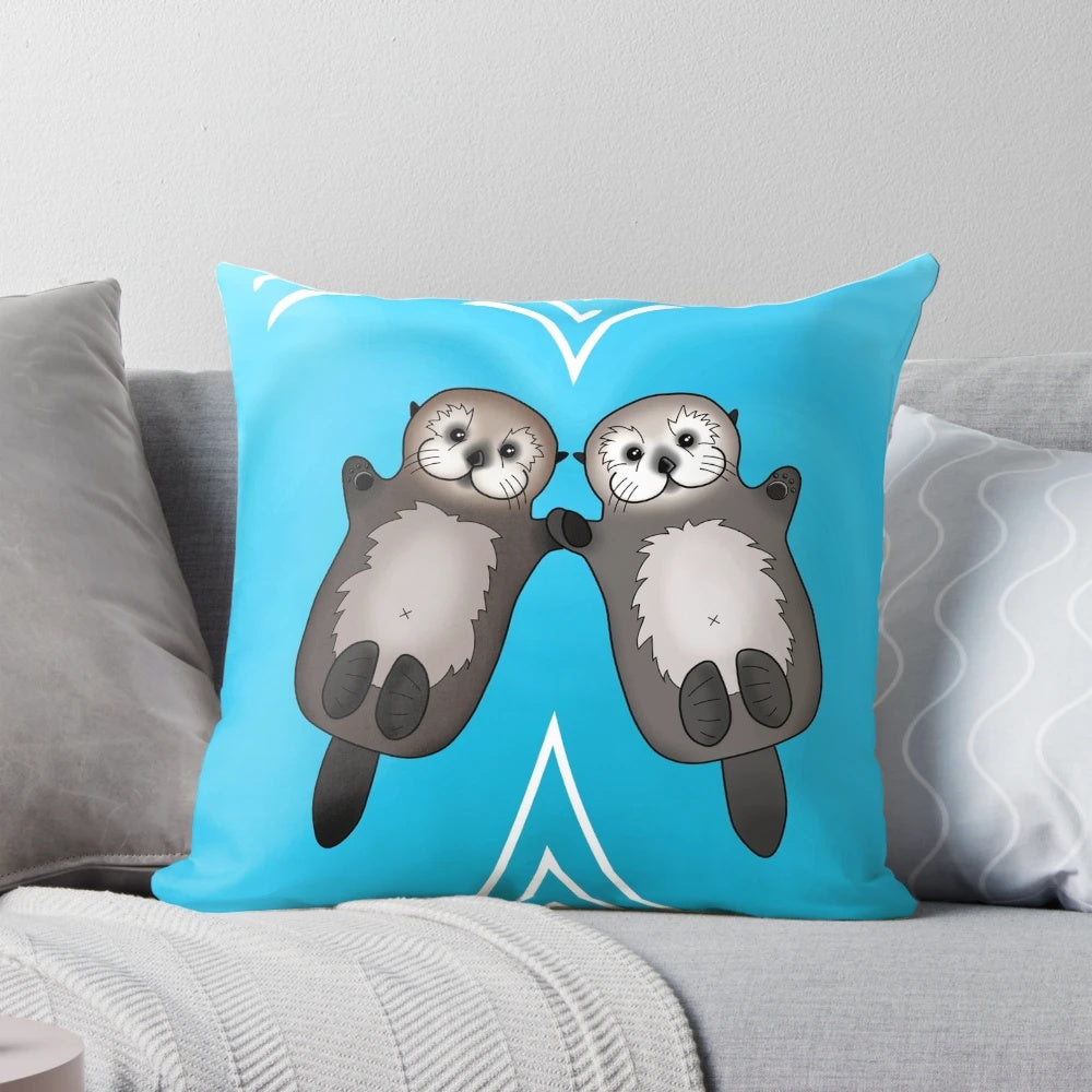 Adorable sea otters holding hands on a plush decorative pillow