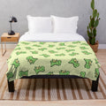 Cuddly T. Rex plush blanket with a green and teal color scheme