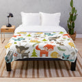 Woodland animals plush blanket with raccoons, deer, foxes, and owls