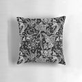 Decorative throw pillow featuring a collage of American traditional tattoo designs including eagle, skull, flower, dagger, snake, rose, sparrow, bee, skeleton hand, and dice.