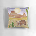 A decorative pillow featuring a cute armadillo in a desert landscape, painted in a batik silk style.