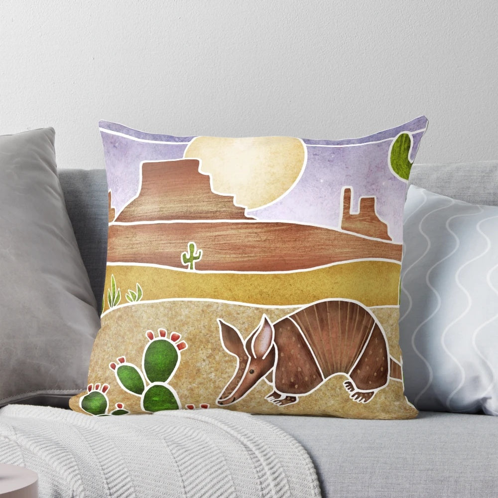 A decorative pillow featuring a cute armadillo in a desert landscape, painted in a batik silk style.