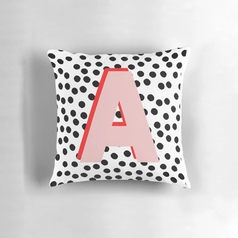 Black and white pillow with dalmatian-inspired spots and a pink letter A