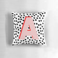 Black and white pillow with dalmatian-inspired spots and a pink letter A