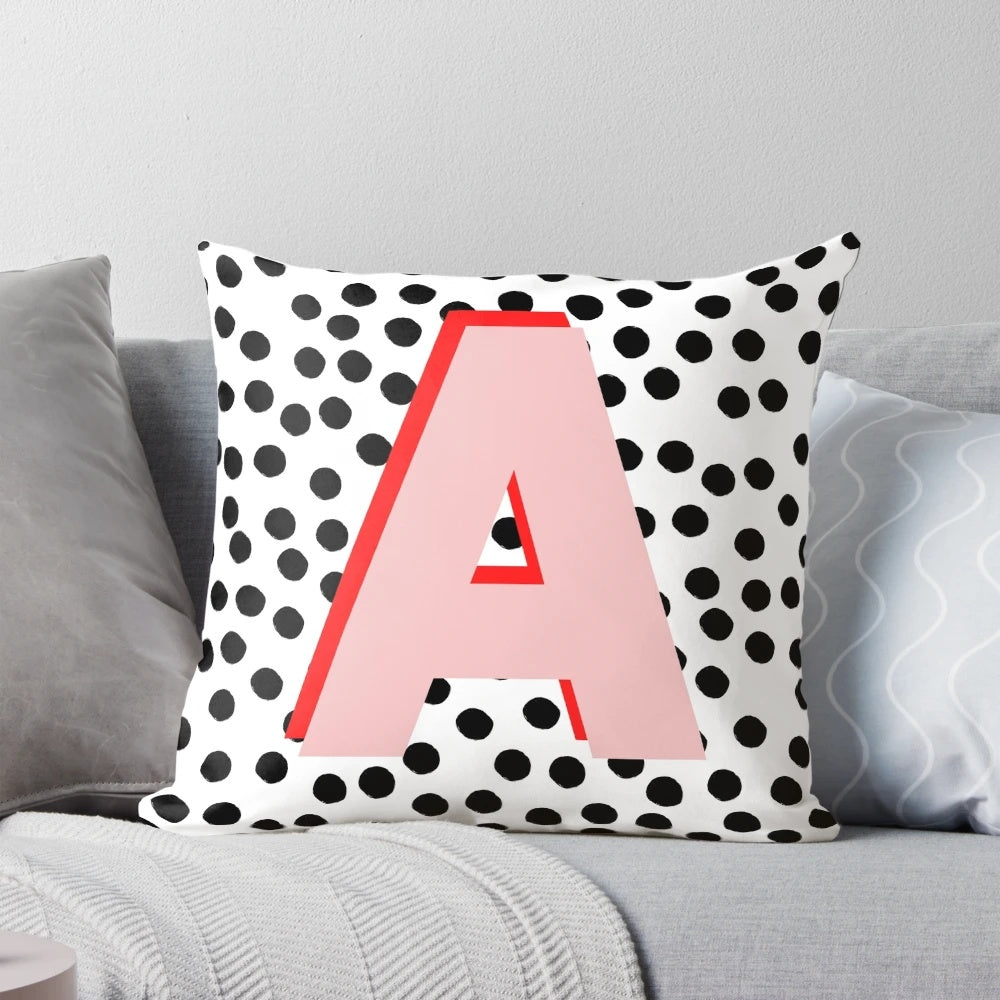 Black and white pillow with dalmatian-inspired spots and a pink letter A