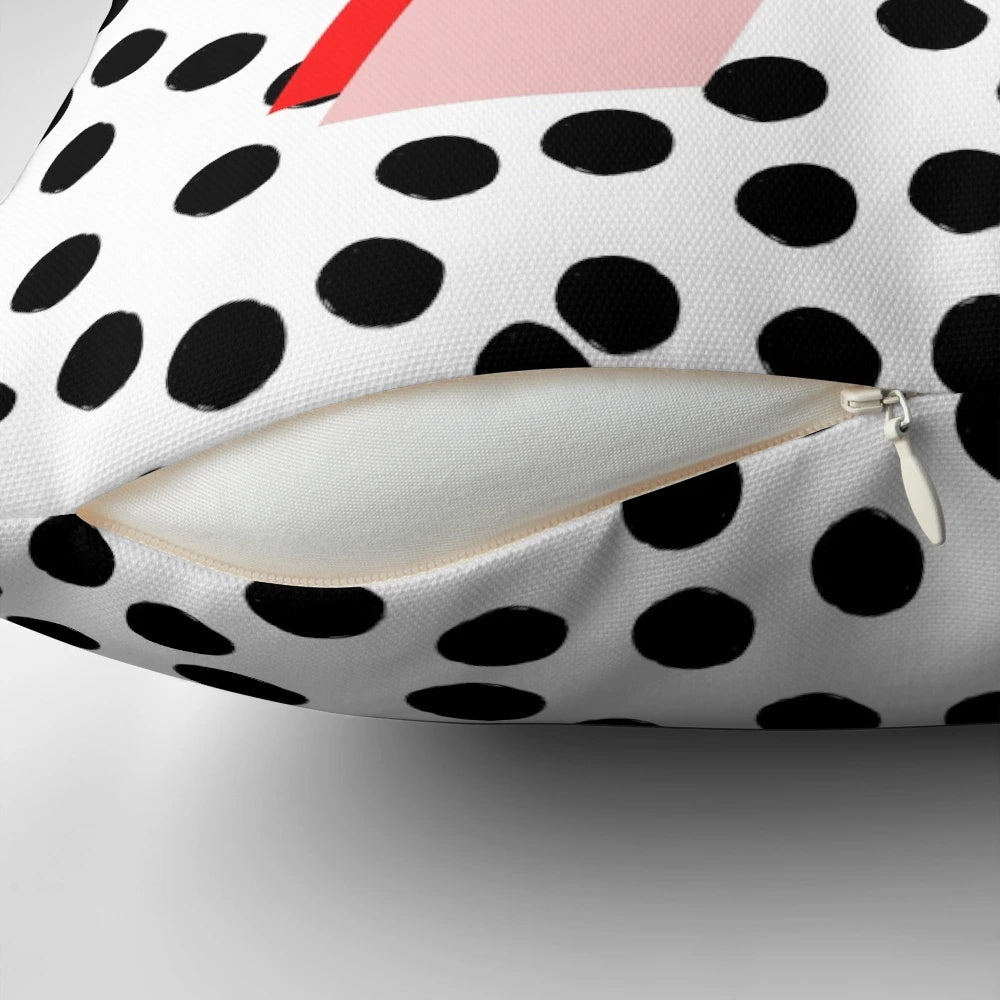 Black and white pillow with dalmatian-inspired spots and a pink letter A