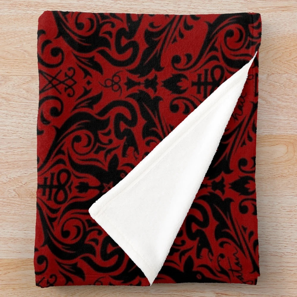 Damask plush blanket with a repeating pattern featuring baphomet, skulls, and other satanic imagery