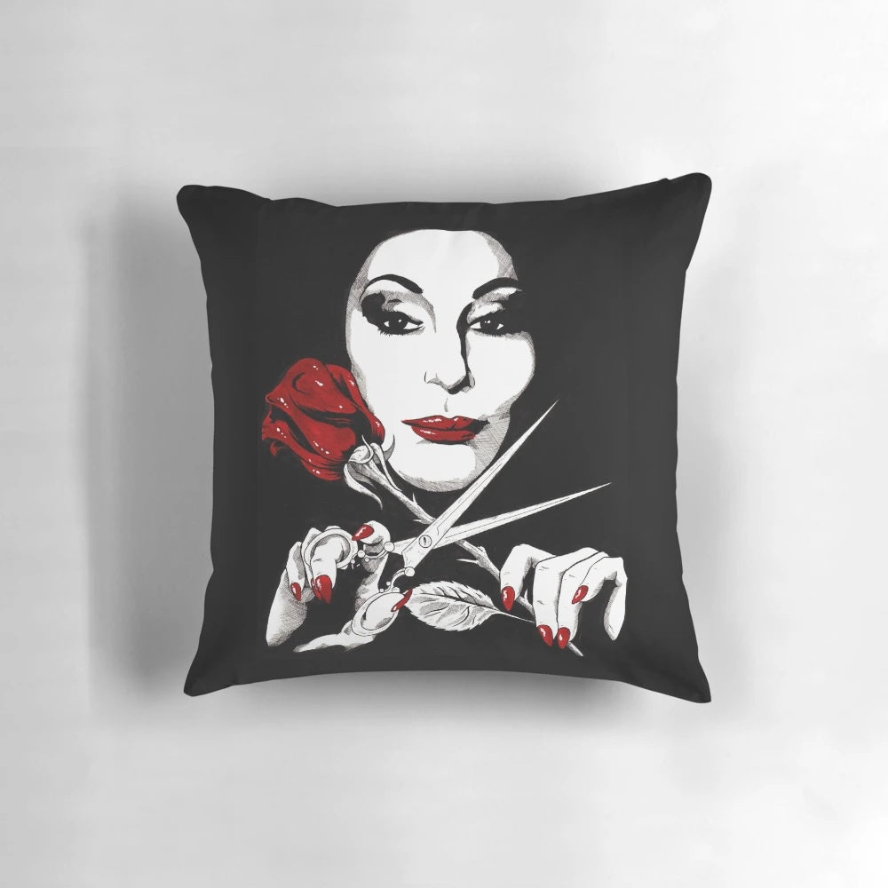 A dark and dreamy throw pillow with an Addams Family-inspired gothic aesthetic, featuring a rose and scissors design.