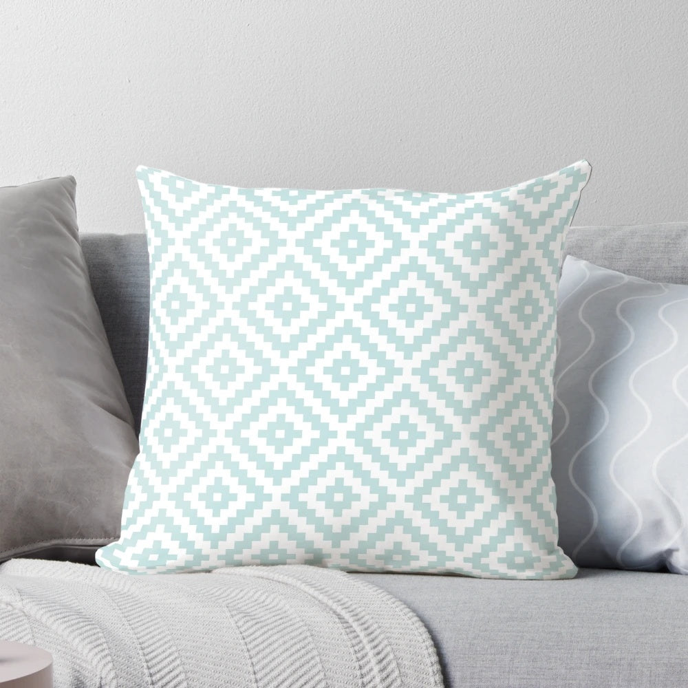Decorative throw pillow featuring an abstract Aztec-inspired pattern in shades of duck egg blue and white.