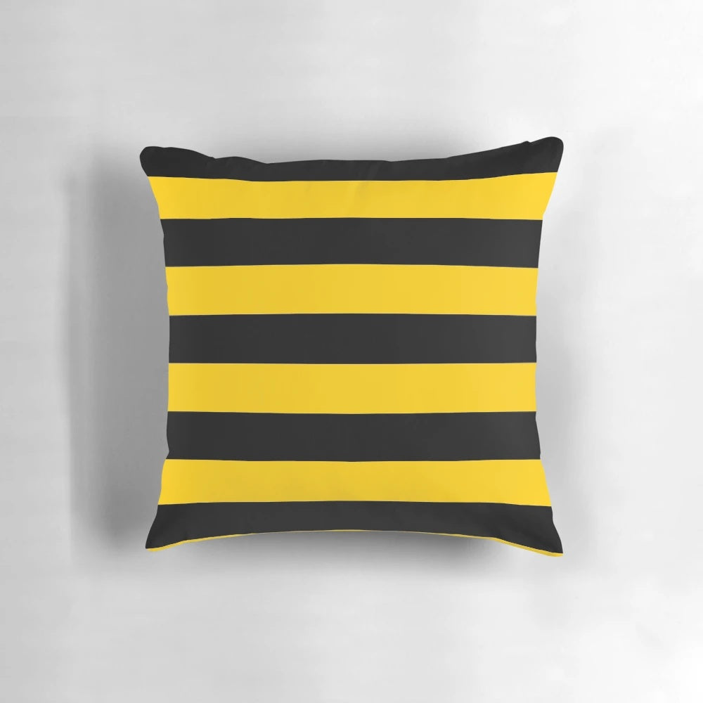 A decorative throw pillow with a stylized bee pattern design featuring black and yellow striped motifs.