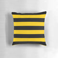 A decorative throw pillow with a stylized bee pattern design featuring black and yellow striped motifs.
