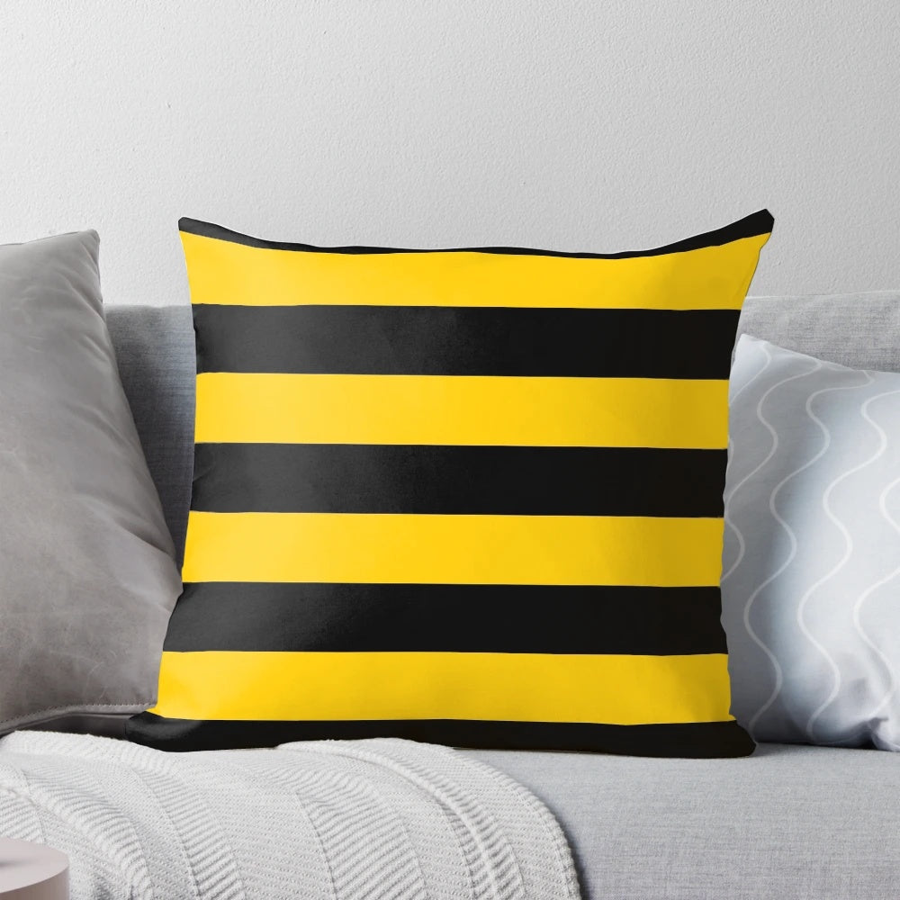 A decorative throw pillow with a stylized bee pattern design featuring black and yellow striped motifs.