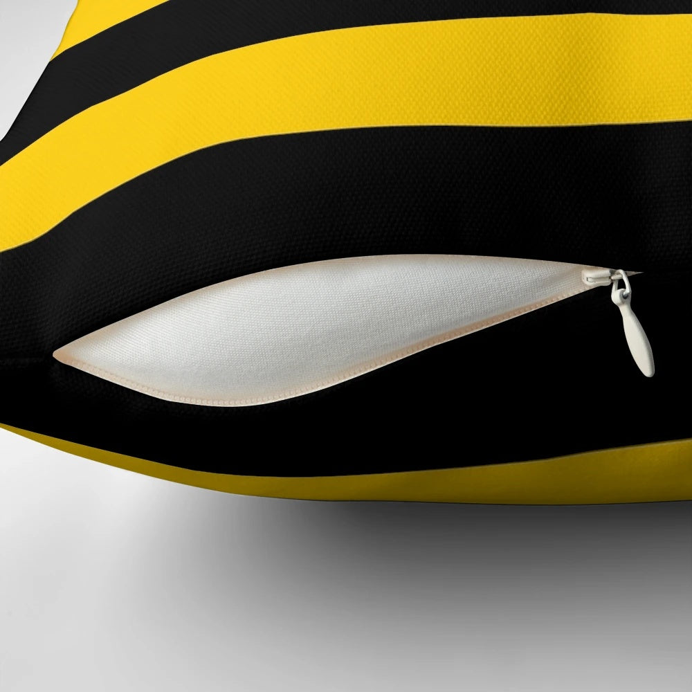 A decorative throw pillow with a stylized bee pattern design featuring black and yellow striped motifs.