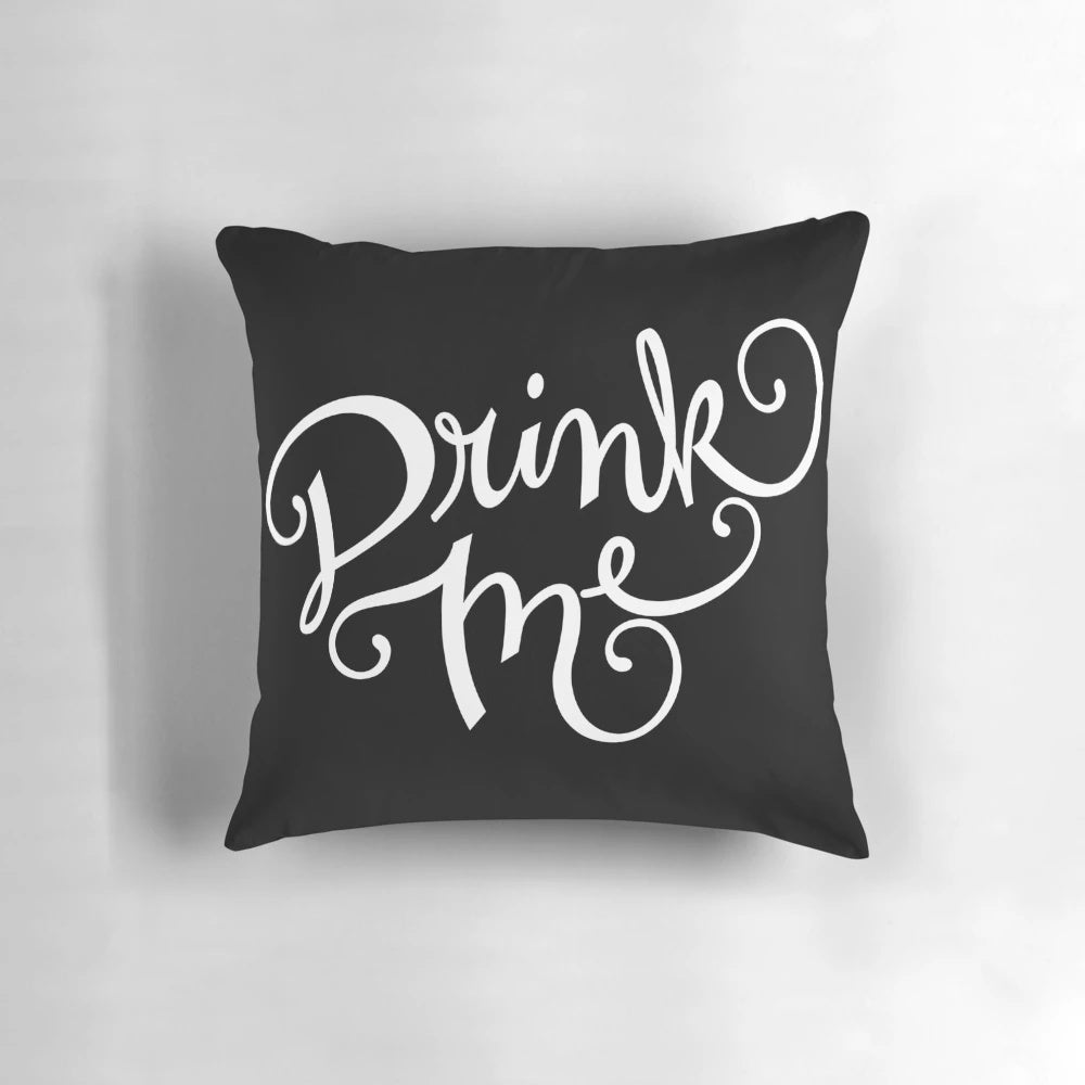 Decorative 'Drink Me' typography pillow with a chalkboard design and cursive lettering, perfect for an Alice in Wonderland-inspired home decor