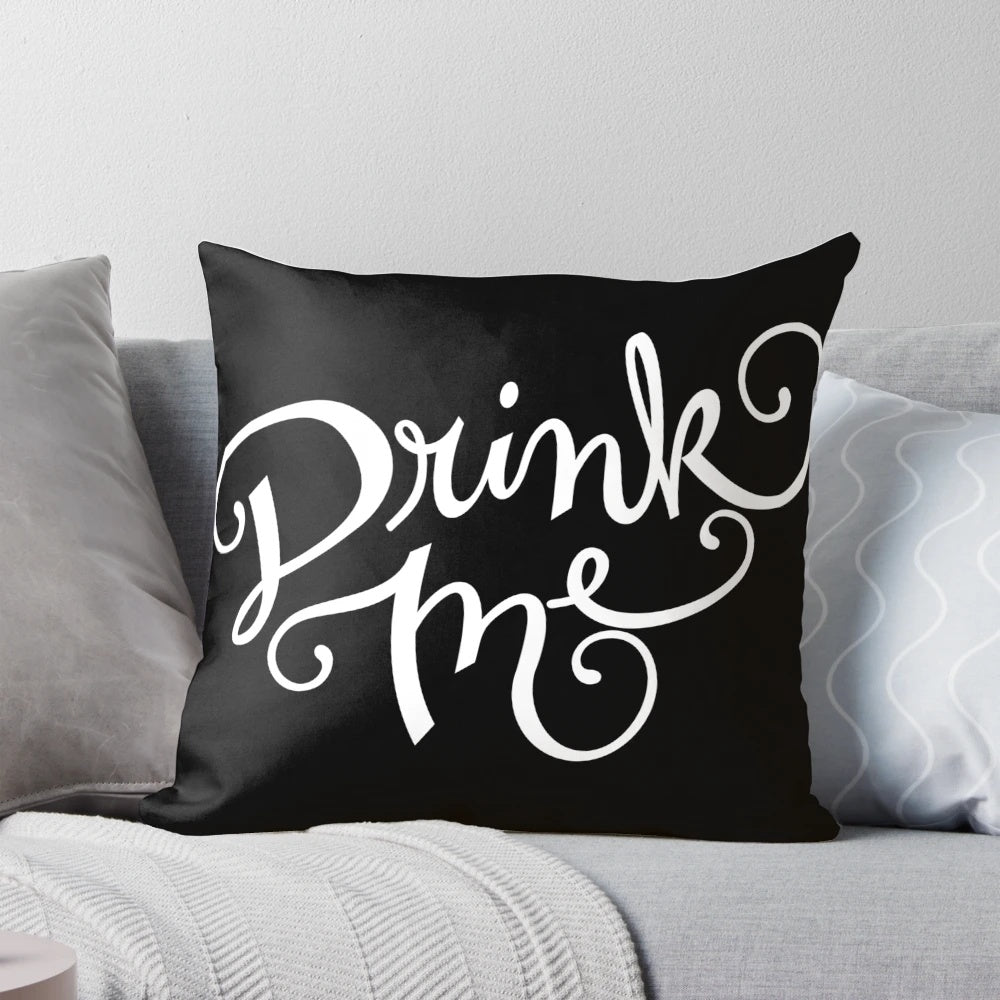 Decorative 'Drink Me' typography pillow with a chalkboard design and cursive lettering, perfect for an Alice in Wonderland-inspired home decor