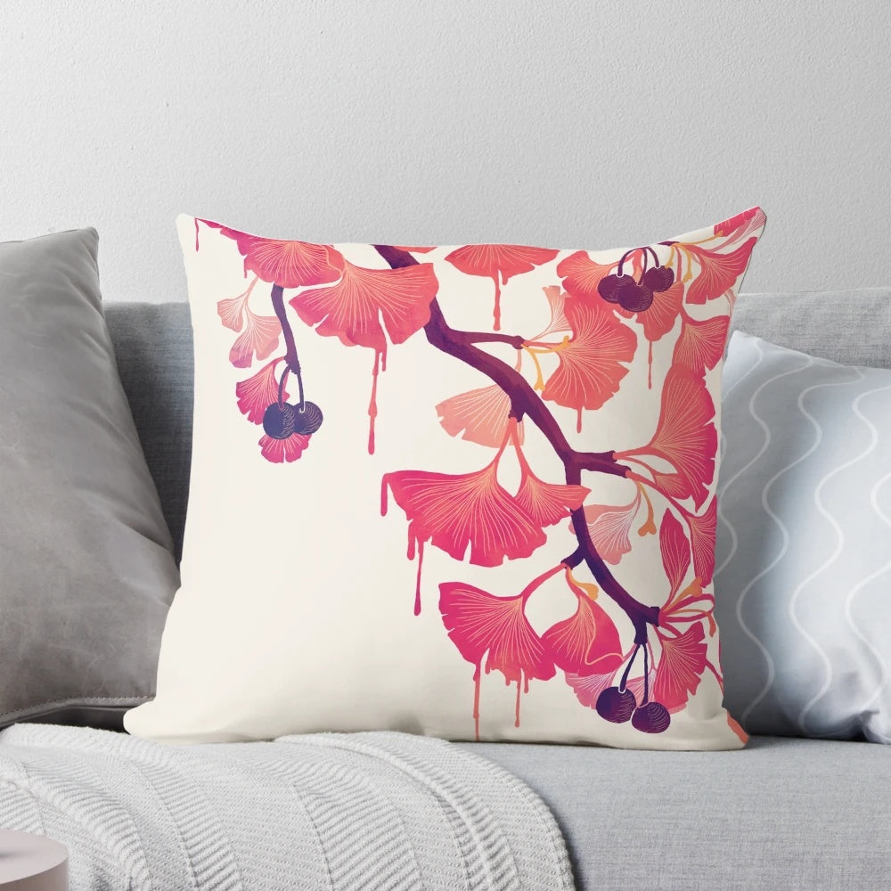 A decorative pillow featuring a whimsical, abstract watercolor design of ginkgo leaves and flowers in soft pink and purple hues.