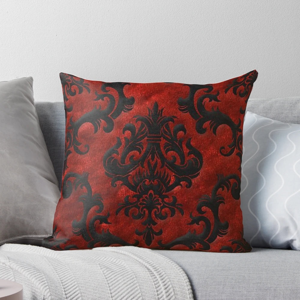A decorative red and black throw pillow with a gothic, spooky pattern.