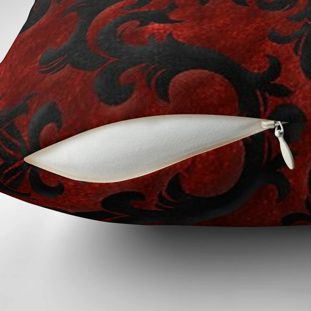 A decorative red and black throw pillow with a gothic, spooky pattern.