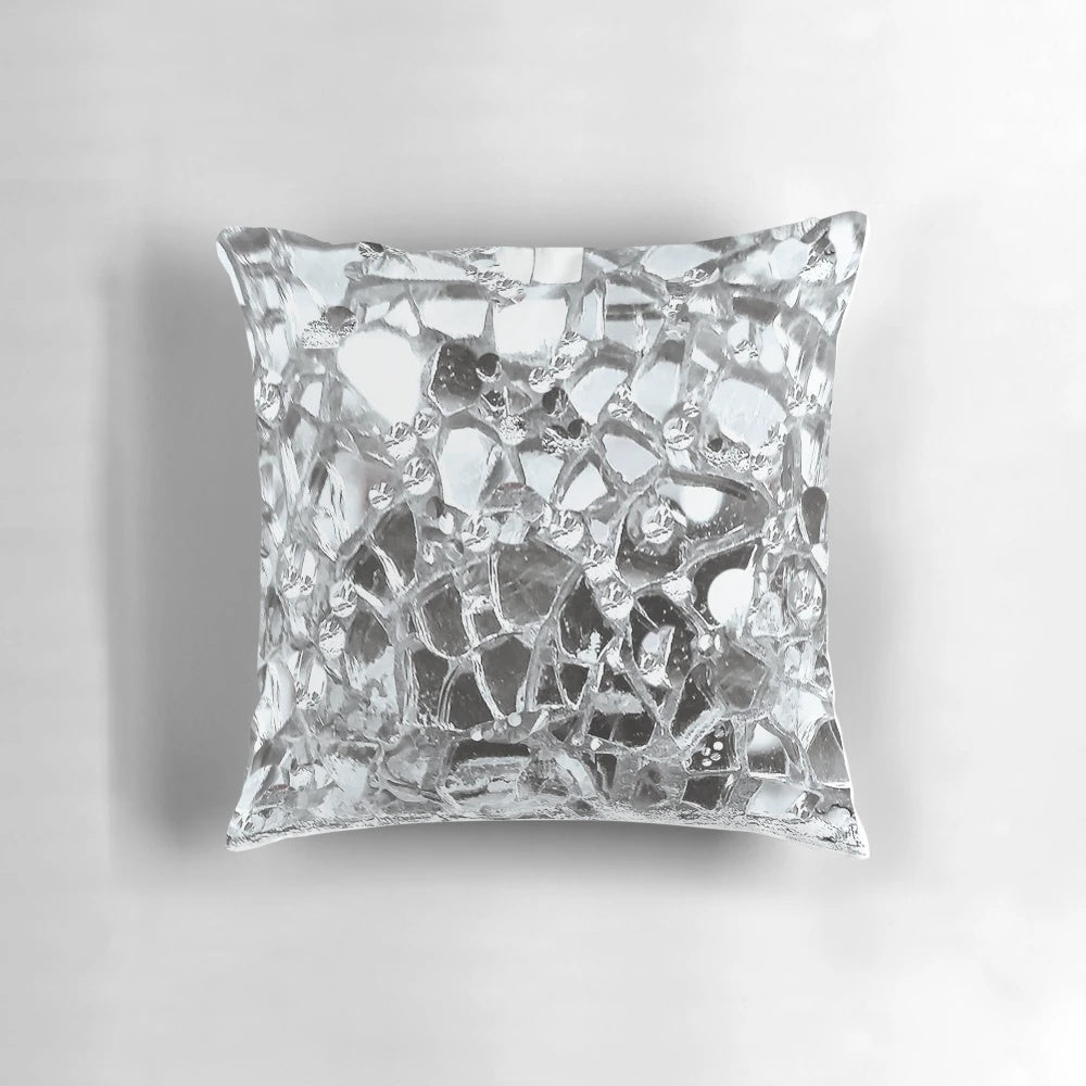 Artistic photographic image of mirrored and glass elements on a decorative accent pillow.