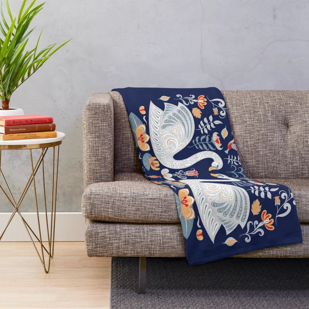 Plush blanket featuring a decorative ornament design with floral, folk art motifs including swans, hummingbirds, and water lilies
