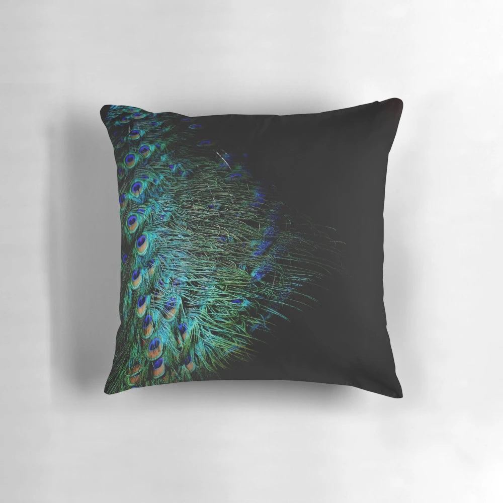 A stylish throw pillow featuring vibrant peacock feathers against a black background.