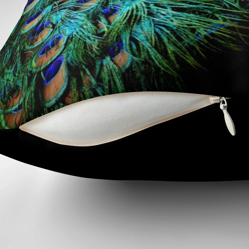A stylish throw pillow featuring vibrant peacock feathers against a black background.
