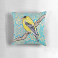 A decorative throw pillow featuring a vibrant illustration of a yellow and black songbird, such as a goldfinch, surrounded by a floral and metallic design.