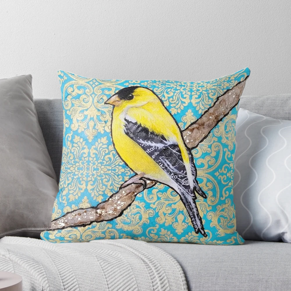 A decorative throw pillow featuring a vibrant illustration of a yellow and black songbird, such as a goldfinch, surrounded by a floral and metallic design.