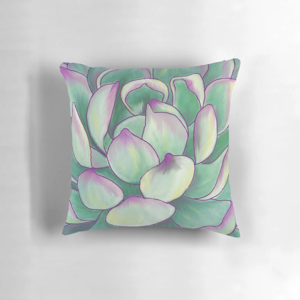 A close-up photograph of a decorative succulent plant pillow with vibrant green and purple colors.