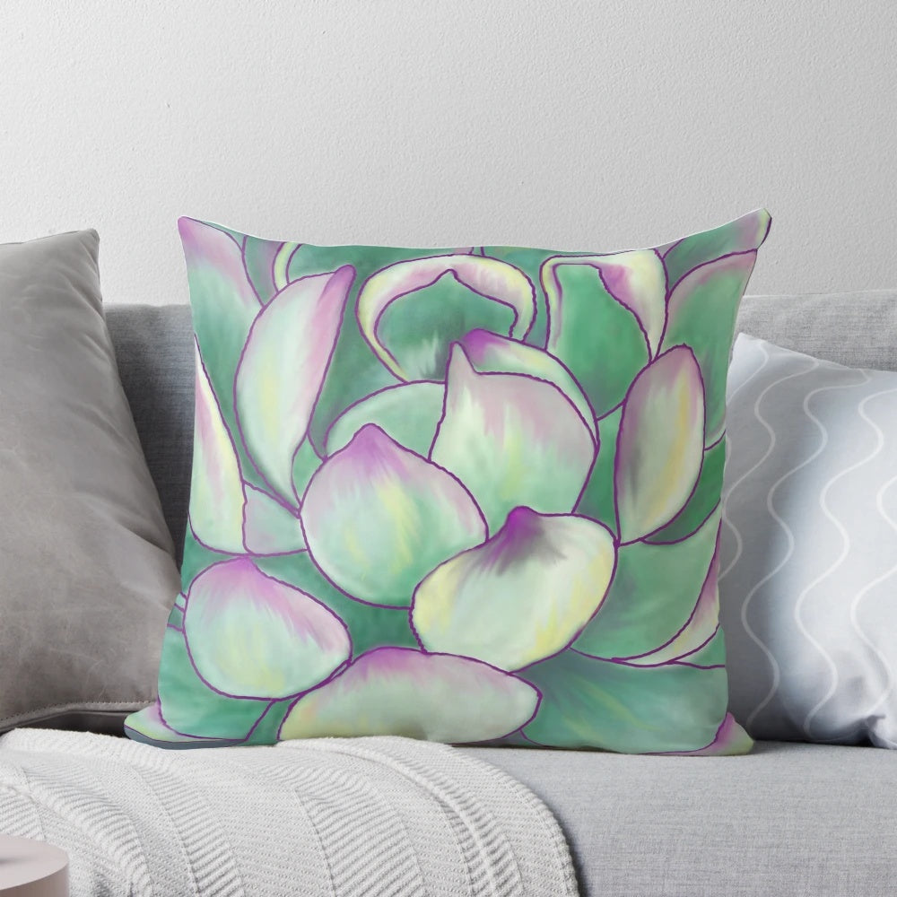 A close-up photograph of a decorative succulent plant pillow with vibrant green and purple colors.