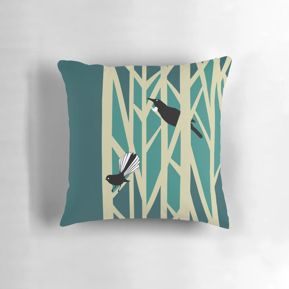 Throw pillow featuring a graphic design of tui and fantail birds perched on trees, a traditional New Zealand nature motif