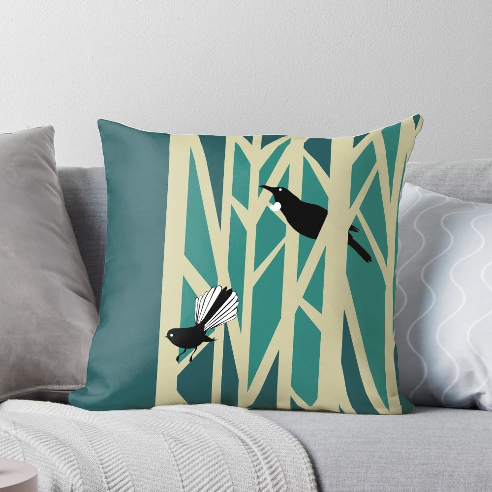 Throw pillow featuring a graphic design of tui and fantail birds perched on trees, a traditional New Zealand nature motif
