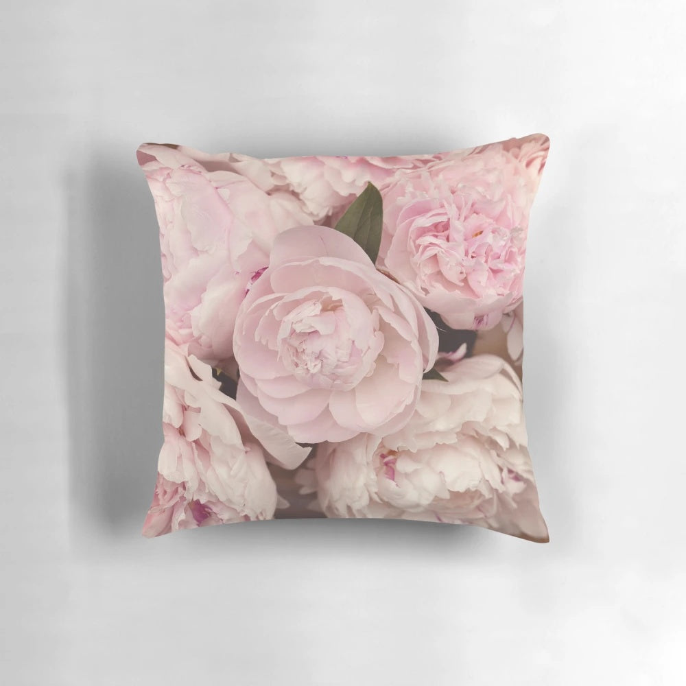 Close-up of soft, pink peony flowers printed on a decorative pillow