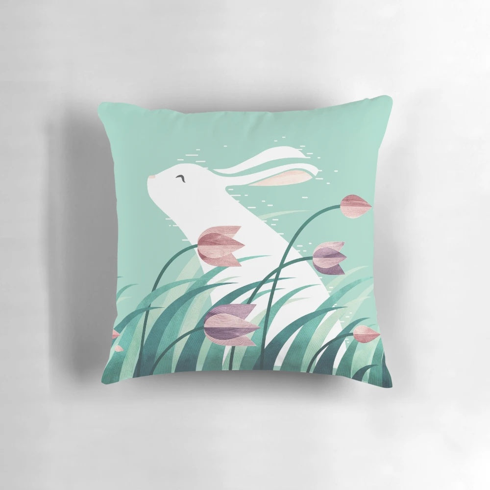Soft and cozy pillow featuring a resting rabbit against a backdrop of floral and nature-inspired patterns