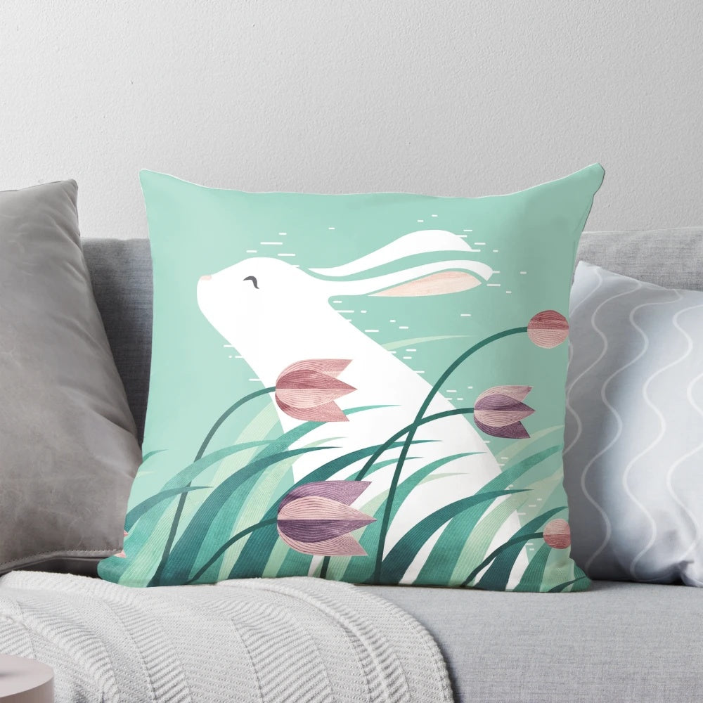 Soft and cozy pillow featuring a resting rabbit against a backdrop of floral and nature-inspired patterns