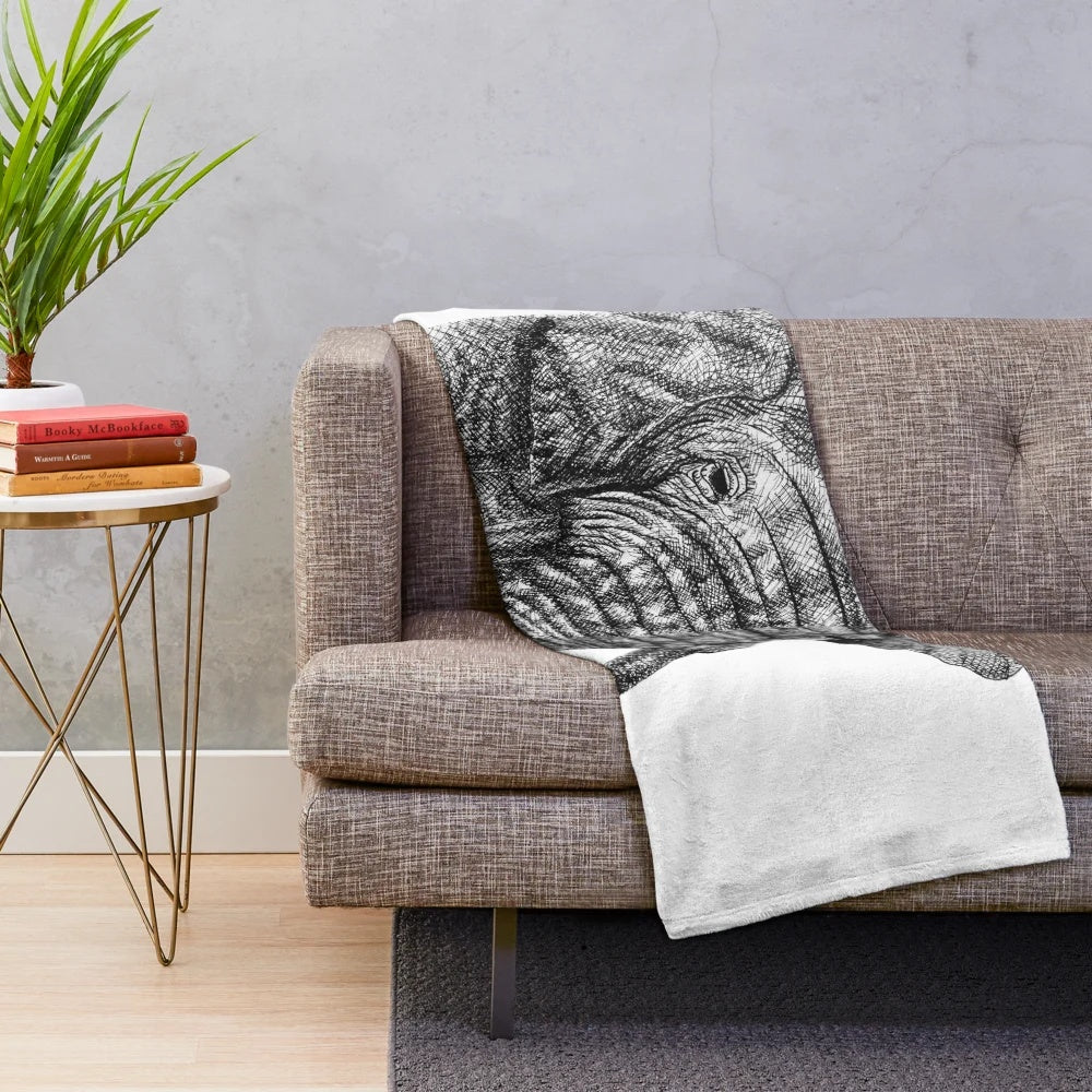 Realistic ink drawing of an elephant on a plush blanket