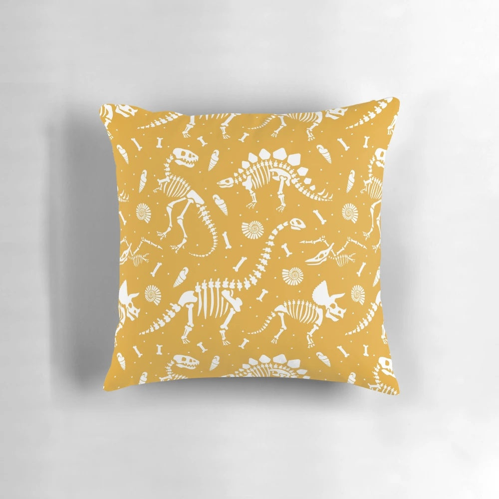 Mustard yellow pillow with dinosaur fossil design, ideal for dinosaur enthusiasts and paleontology fans.