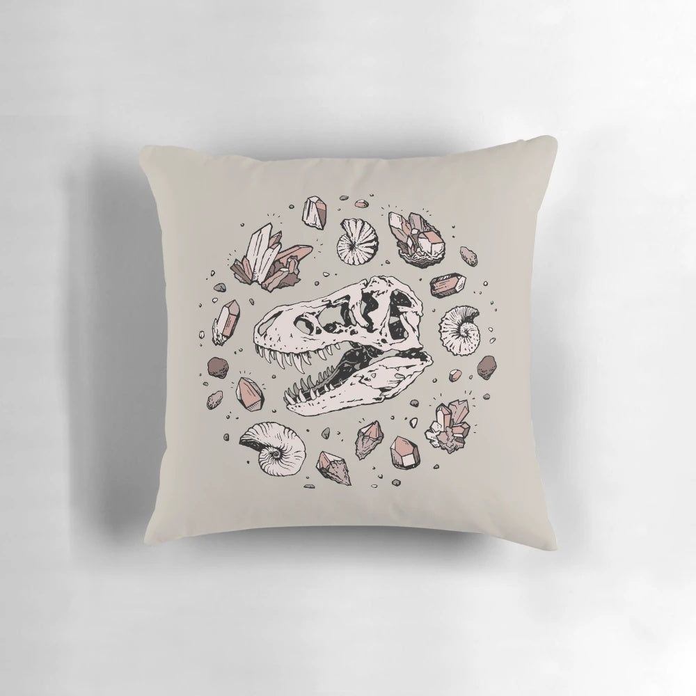 Pillow featuring a hand-drawn illustration of a dinosaur skull fossil, including a tyrannosaurus rex bone structure and rose quartz mineral.
