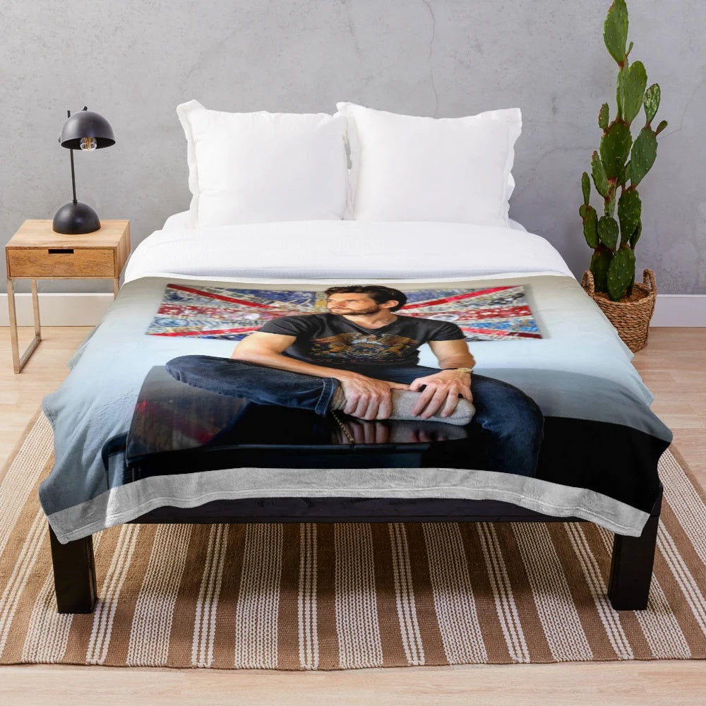 Ben Barnes playing the piano on a plush blanket
