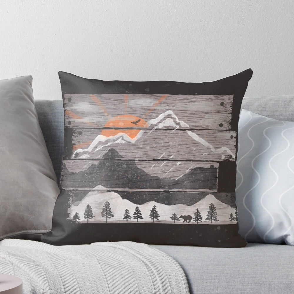 Cozy grey pillow with nature-inspired design featuring mountains, sunset, and wildlife